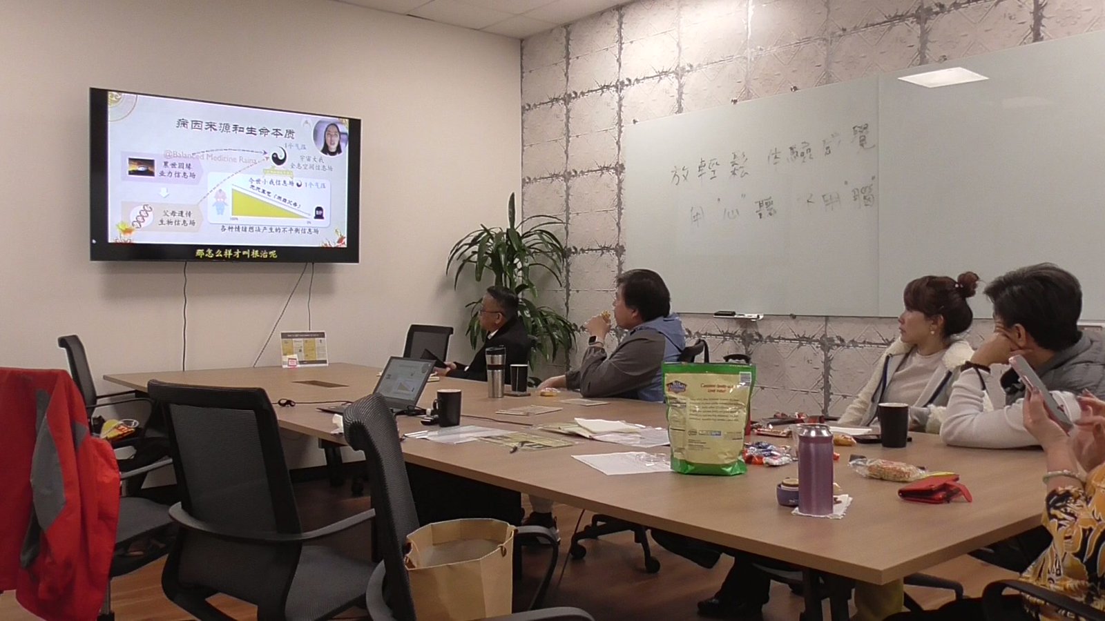A community talk in a conference room, attendees watching the presentation screen