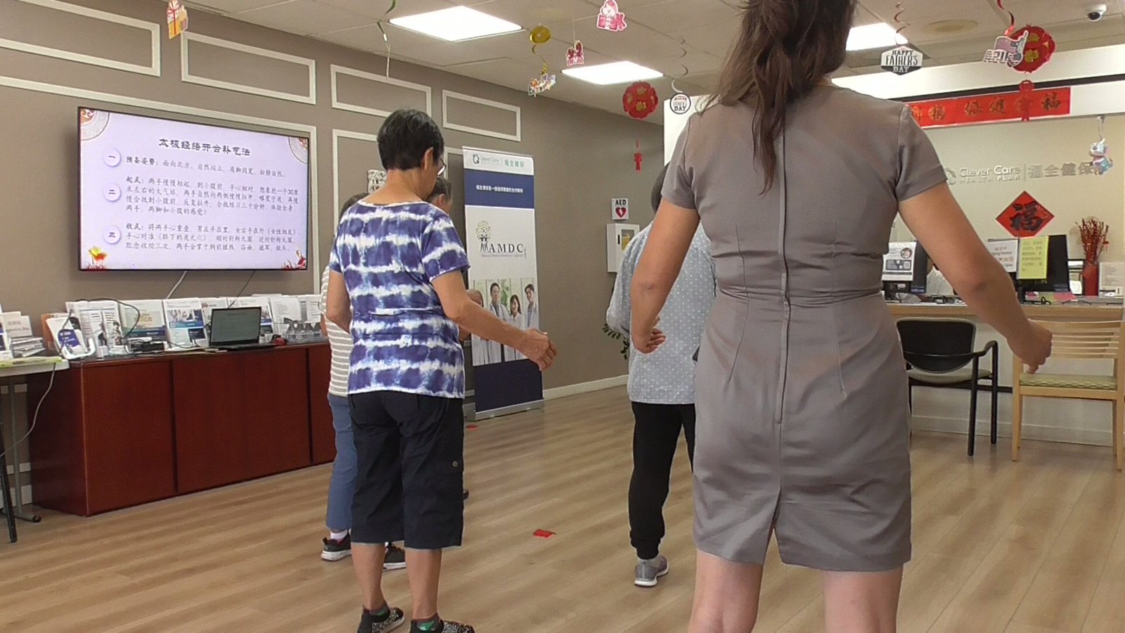 A senior group following the practice together in a community space, seen from behind
