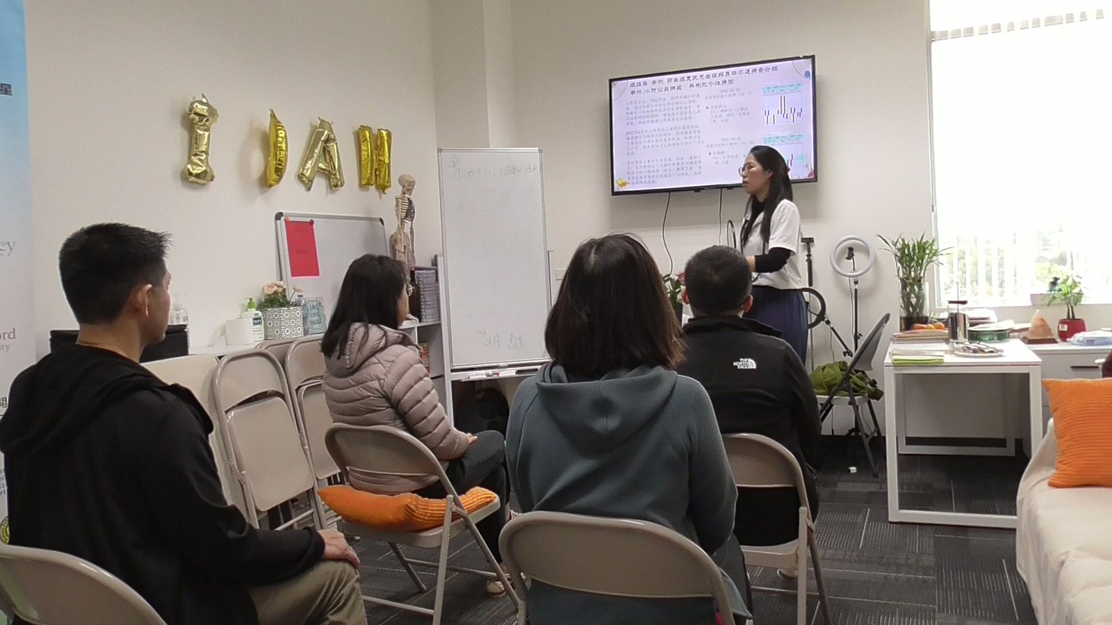 A small class following the instructor in a studio, seen from behind